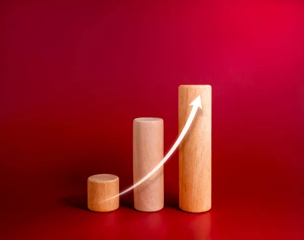 Rise up increase arrow on wooden sticks as chart steps isolated on red background, minimalist. Inflation, business growth graph process, goal, success, and economic improvement and analysis concepts.