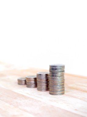 Yatırım, büyüme finans sektörü, para, gelir ve satış kar kavramlarının artırılması. Gümüş paralar, bir büyüme grafiği olarak yığın ahşap masa ve beyaz arka plan, dikey biçim.