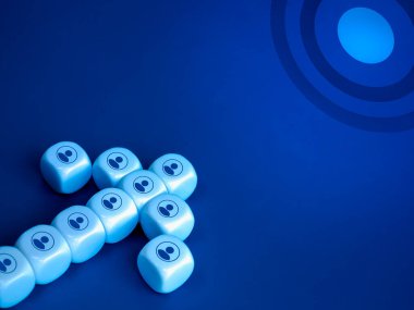 Liderlik, iş büyümesi ve başarı, takım çalışması, organizasyon, meslektaşlık, takım işbirliği kavramları. Beyaz zar bloğu ok şeklindeki kişi simgesi mavi arkaplandaki büyük hedef hedefe yöneliyor.