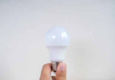 Modern temiz beyaz LED ampul ya da beyaz arka planda elle izole edilmiş bir lamba. Geri dönüşüm enerjisi ve yaratıcılık fikri kavramları.