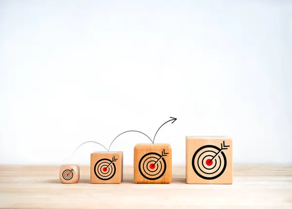 Small steps to archive big win. The power of micro goals, business  concept. Arrow jumping on wooden cube blocks with target dart icon from small to large isolated on white background with copy space.