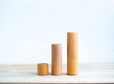 Üç adet yuvarlak ahşap çubuk, beyaz arka plandaki ahşap masada izole bir şekilde duran bir iş haritası. İş büyümesi grafik süreci, hedef, başarı ve ekonomik iyileştirme kavramları.