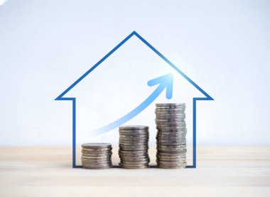 Büyüme grafiği ahşap masa ve beyaz zemin üzerinde mavi ev şeklindeki sembollerle adım atarken para birikintisindeki yukarı ok. Tasarruf, gelir, ev yatırımı, gayrimenkul fiyatı, gayrimenkul karı kavramları.