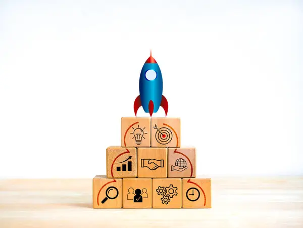 Business startup with growth success process for leadership concept. Space rocket launching on top of wooden cube blocks pyramid shape with strategy marketing action plan icons on white background.