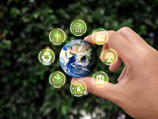 Reduce CO2 emissions, world and environmental sustainability care, net zero carbon dioxide reduction concept. Small earth hold by hand with green renewable energy and ESG icons on leaves background.
