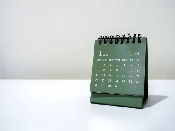 A January 2024 calendar desk for organizer to plan and reminder isolated on white background with copy space, minimal style. Green small table calendar with first month page, Happy new year 2024.