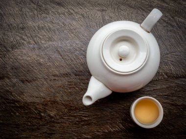 Çaydanlıklar hazır. Sıcak çay fincanlarıyla geleneksel beyaz seramik çaydanlık eski tip ahşap masa üzerinde fotokopi alanı ile hazırlanıyor..
