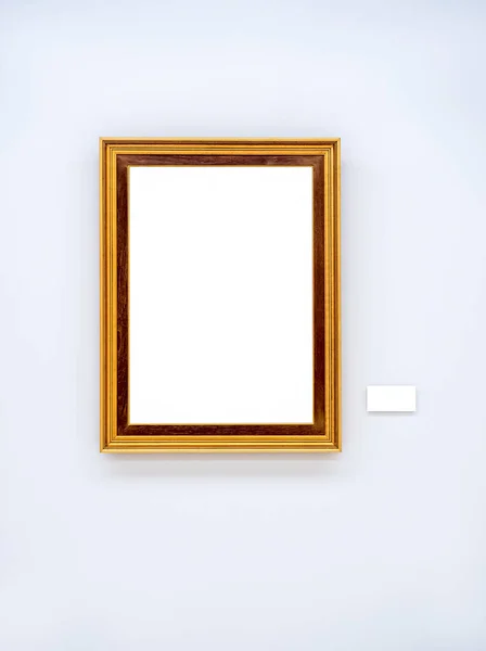 Mockup white blank space in gold wooden square picture frame, vertical style, isolated. Empty single vintage brown rectangular simple photo frame hanging on white wall background with empty caption.