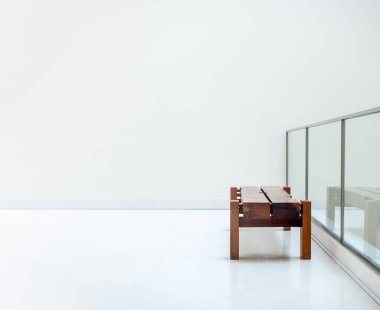 Kalın kesimli taşra meşe tezgahında kimse yok. Modern binanın içinde cam bölme çitlerinin yanındaki beyaz bir duvarda boş, kahverengi, uzun, ahşap bir bank koltuğu..