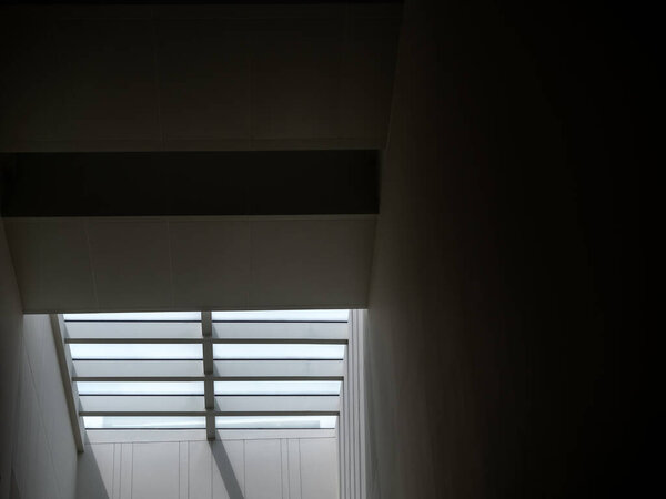 Ant eyes view of ceiling window glass roof decorating the modern building's interior, to add the sunlight to come inside, with copy space. Play with light and shadow management construction design.