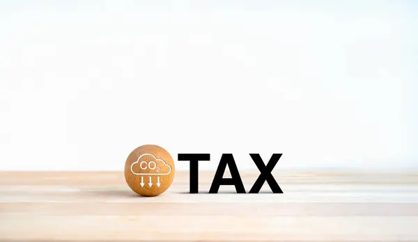 Carbon tax. Carbon emission icon on wood ball with. Black text, TAX on wooden desk and white background with copy space. Environmental, social responsibility business and carbon emission concept.