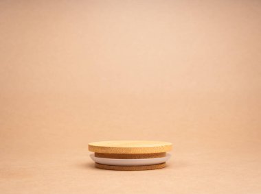 Yuvarlak ahşap yığını, geri dönüşüm kâğıdı arka planında izole edilmiş kozmetik ürünleri tasarlayan boş yiyecek alanı olan bir podyum. Kahverengi kraft kağıt arka planda model görüntüleme, çevre dostu konsept.