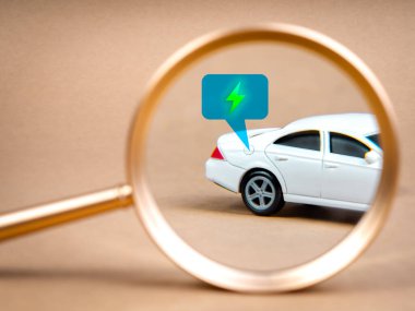 EV araba araması, sürdürülebilir geliştirme kavramına sahip elektrik enerjili akü şarj aracı. Büyüteçle beyaz arabanın yakıt deposu kapağında konuşma balonunda yeşil elektrik enerji ikonu.