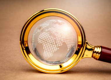 Küresel trendler, dünya çapında müşteri sezgileri, dijital çevrimiçi bağlantı teknolojisi ve iş pazarlaması, web tarayıcı konsepti. Kahverengi arka planda büyüteç içinde yakın çekim dijital küresi.