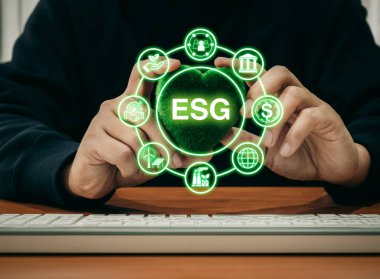 Çevresel, sosyal ve kurumsal yönetim, dünyayı kurtarmak için sürdürülebilir çevre. ESG kısaltması ESG element simgeleriyle çevrili ve iş yerinde yeşil kalp topu taşıyan bir adam var..