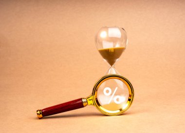 Tax time deadline concept. Percentage icon in magnifying glass lens on hourglass, isolated on brown recycled paper background, minimal style. Interest Rate Swap (IRS), Time limit for annual taxation. clipart