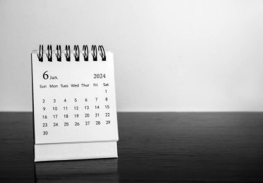 Bir Haziran 2024 masa takvimi. Organizatörün, siyah masa üzerinde fotokopi alanı ile birlikte beyaz zemin üzerinde planlaması ve hatırlatması için. Altıncı ayın tarih sayfası olan beyaz küçük masa takvimi.