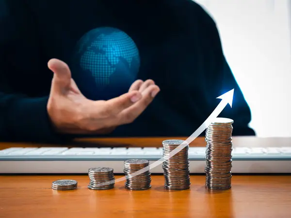 stock image Investment online, taxable income, worldwide business jobs concept. Rising arrow on coin stacks as growth graph steps while businessman's hand holding virtual digital world globe on dark background.