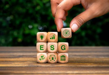 ESG, çevre, sosyal ve kurumsal yönetim, dünyayı kurtarmak için sürdürülebilir çevre, kavram. Hedef simge bloğu ahşap küpün üzerine ahşap blok yığınının üzerine ESG simgeleri, yeşil arkaplan.