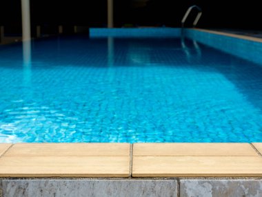 Yaz havuzu geçmişi. Havuz kenarındaki boş alan, taştan fayanslar ve tropik tatil beldesindeki bulanık yüzme havuzu, ürünlerinizi göstermek veya montajlamak için yaz arkaplanı.