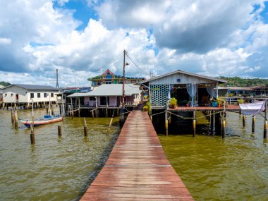 BANDAR SERI BEGAWAN, BRUNEI - 21 Nisan 2024: Kampong Ayer 'deki ahşap köprü, Bandar Seri Begawan' daki Brunei nehrinin önde gelen geleneksel yerleşim köyü sahnesi, turizm beldeleri.