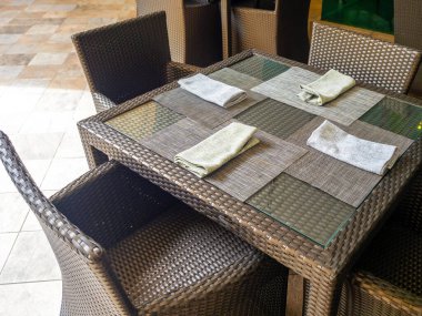 Beyaz keten peçeteler kaşık ve çatalla kaplı tabak paspasları boş sandalye koltukları, masa takımı otel, açık hava, üst manzara konukları için hazırlanıyor..