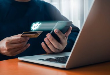 Güvenli ödeme konsepti. Güvenlik kalkanı simgesi, hologram, kredi kartıyla cep telefonu alışverişi, online alışveriş ve bankacılık, dijital işlem.