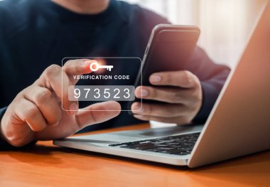 İki faktör doğrulaması ya da 2FA konsepti. Şifreyi, güvenli adımları, siber güvenlik teknolojisini onaylamak için akıllı telefon ve dizüstü bilgisayarı kullanırken insan eliyle tuş simgesi içeren doğrulama kodu.