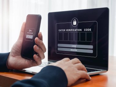 2FA ya da iki faktör doğrulaması, siber güvenlik kavramı. Doğrulama kodu için boş parola kutusu laptop ekranında gösterilirken iş adamı akıllı telefonu tutuyor ve güvenlik için parola anahtarı alıyor.