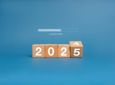 Mutlu Noeller ve 2025 yılının afişleriyle karşınızdayız. İlerleme çubuğu ahşap kaldırma bloklarında 2024 değişiklikle birlikte açık mavi arka planda 2025 yıllık rakamlar yükleniyor, minimalist.