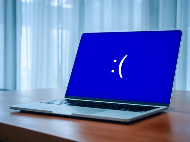 Sistem hatası kavramı. Mavi ekranda ölüm ya da BSOD görüntüsü, büyük üzgün duygu ifadesi, masadaki mavi ekranda ifade, problem ya da boş odada bir şeyler ters giderken,.