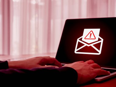 SMS spam, sahte mesaj dolandırıcı konsepti. Açılmış zarftaki uyarı simgesi, e-posta hacklenmesi, dolandırıcılık virüsünün bilgisayar ekranına yayılması..
