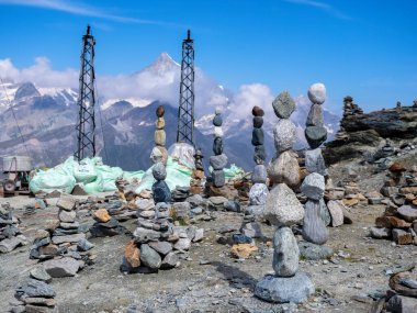 Tepe dağları ve mavi gökyüzü arka planında bir çok uzun kaya cairn, Gornergrat yüksek istiflenmiş kaya, Matterhorn, Zermatt, İsviçre görmek için son tren istasyonu veya turist için..