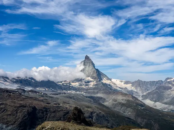 İsviçre Alplerinde Matterhorn Tepesi 'nin dönüm noktası. Mavi gökyüzü arka planında beyaz kabarık bulutlu Matterhorn 'un inanılmaz manzarası. İsviçre 'de yaz dağları olan bir turizm merkezi.