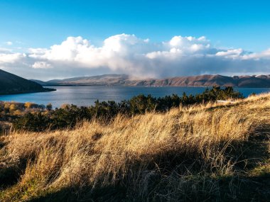 Güzel sonbahar manzarası Sevan Gölü 'nde esen rüzgar Sevanavank Manastırı yakınlarındaki tepenin manzarası mavi gökyüzünde birçok dağ ve Ermenistan' ın arka planında tüylü bulutlar..