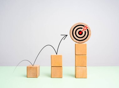 İş büyümesi, başarı konsepti çabaları. Tahta küp bloklardaki hedef simgeye atlayan ok yeşil tablo, beyaz arkaplan, minimalist ve eko stili üzerinde büyüyen grafik olarak 3 aşama oluşturdu.