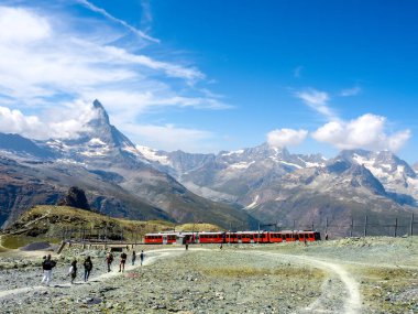 Demiryolundaki kırmızı tren Gornergrat istasyonuna gidiyor. Yürüyen insanlarla turist, Matterhorn 'da, dağların manzarası, Zermatt, İsviçre' de yaz mevsimi..