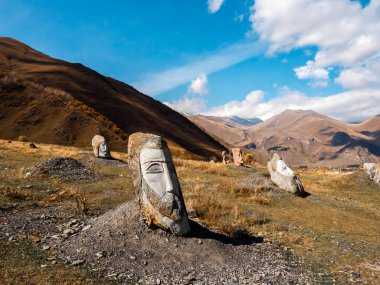 Sno, Kazbegi, Gürcistan - 12 Ekim 2024: Dev insan kafaları, Merab Piranishvili heykelleri, sonbahar dağları ve mavi gökyüzü arka planı, Gürcistan 'da turistik cazibe.