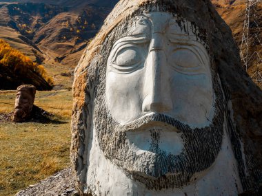 Sno, Kazbegi, Gürcistan - 12 Ekim 2024: Dev taş kafa, dev insan kafaları koleksiyonu, Merab Piranishvili heykelleri, sonbahar dağları arka planında, Gürcistan 'da turistik cazibe.