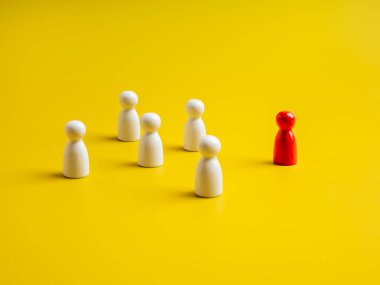 Kırmızı olan, sarı arkaplanda beyaz mandallı bebeklerden, insan sembollerinden oluşan gruptan farklı duran. Kalabalıktan, liderlikten, eşsizlikten, etkileyicilikten, özel insanlardan, farklılıklardan....