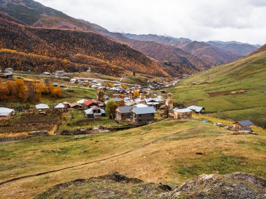Tepeden, Ushguli köyünden, UNESCO 'nun mirasından, dağlara yakın pek çok evi ve sonbahar manzarası olan, Gürcistan' ın Svaneti bölgesindeki turistik merkezi.
