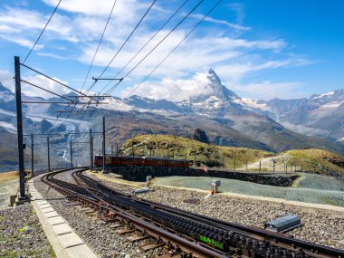 Zermatt yakınlarındaki Gornergrat tren istasyonuna giden kırmızı turist treni rayları. Muhteşem bir manzarası, Matterhorn tepesi, mavi gökyüzü arka planı, İsviçre 'de ünlü turizm merkezi..