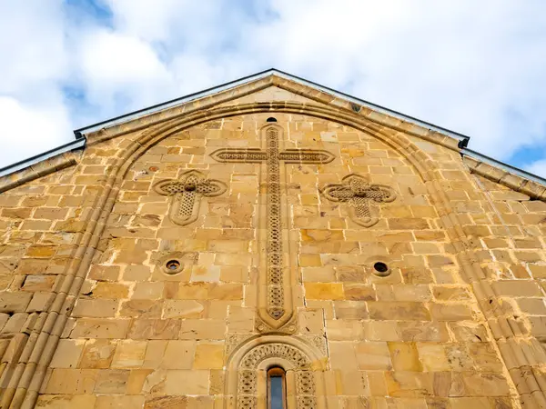 Ananuri Kalesi, mavi gökyüzü arka planındaki kilise binalarının duvarlarında büyük bir haçla, Ananuri köyünde tarihi bir dönüm noktası olan kale kompleksi, Gürcistan 'da popüler bir turizm merkezi..