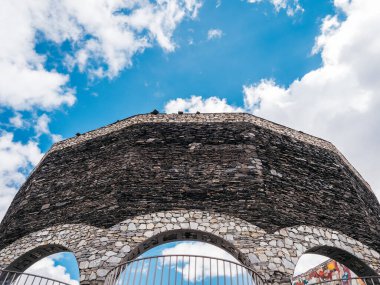 Gudauri, Gürcistan - 12 Ekim 2024: Rusya - Gürcistan Dostluk Anıtı, taş duvarda teras ve tarihli beton yapı, büyük fayans duvarlarında sanat, Gürcistan 'da seyahat hedefi.
