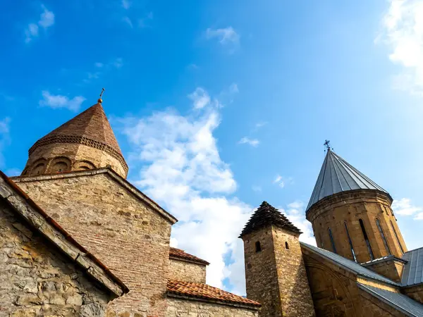 Ananuri Kalesi, iki kilise kulesi, mavi gökyüzü arka planında eski binalar, Gürcistan 'da popüler bir turizm merkezi olan şato kompleksi ile Ananuri köyünün tarihi simgesi..