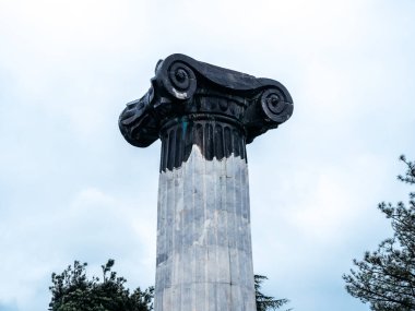 Gürcistan Günlükleri, yağmurlu bir günde anıtın girişindeki siyah beyaz sütun, Gürcistan 'ın Tiflis Denizi yakınlarındaki Keeni tepesinde yer alan ünlü turistik eğlence, yağmurdan sonra beyaz sisli gökyüzü.