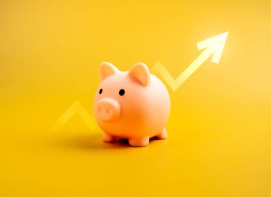 Sarı arka planda yalıtılmış yükselen oku olan sevimli pembe domuzcuk kumbarası, minimal tarzda. Tasarruf parası, satış karı, kazançlar, özel giderler, kredi ve iş kredisi, bankacılık ve finans kavramları.