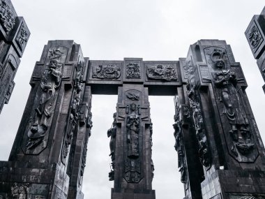 Gürcistan Günlükleri, anıt tarihi, siyah heykel sütunları tasarım ayrıntıları, Tiflis Denizi yakınlarındaki Keeni tepesinde yer alan ünlü turistik cazibe, yağmur gününden sonra beyaz sisli bir gökyüzü..