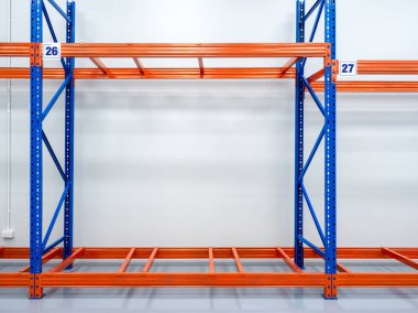 Boş kırmızı ve mavi metal depo rafı, üzerinde numara levhası olan çelik raflar, parlak beyaz, temiz fabrika arka planına monte edilmiş. Ürün depolama sistemi, endüstriyel konsept.