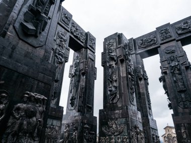 Gürcistan Günlükleri, anıt tarihi, siyah heykel sütunları tasarım ayrıntıları, Tiflis Denizi yakınlarındaki Keeni tepesinde yer alan ünlü turistik cazibe, yağmur gününden sonra beyaz sisli bir gökyüzü..